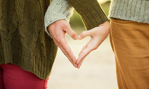 Par håller handen som ett hjärta