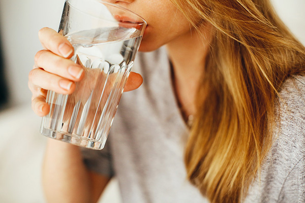 Kvinna dricker ett glas vatten